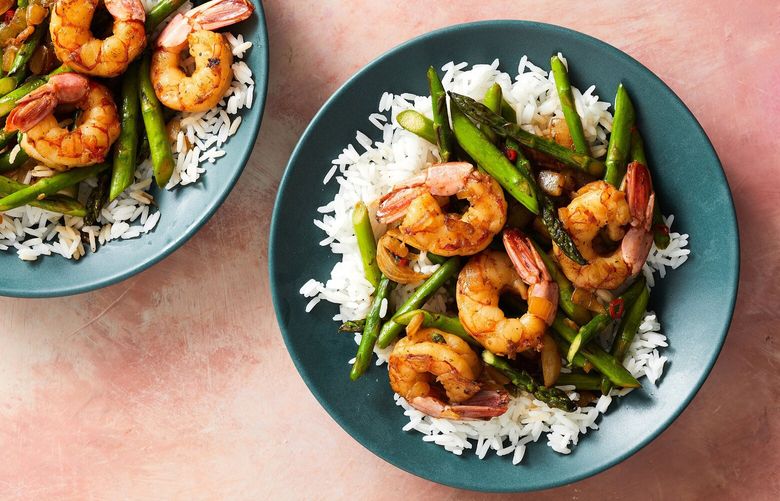 Shrimp and asparagus stir-fry. Placing frozen shrimp under running water, then rubbing them with salt, helps keep them snappy. Food styled by Spencer Richards. (Kerri Brewer/The New York Times) XNYT0569 XNYT0569