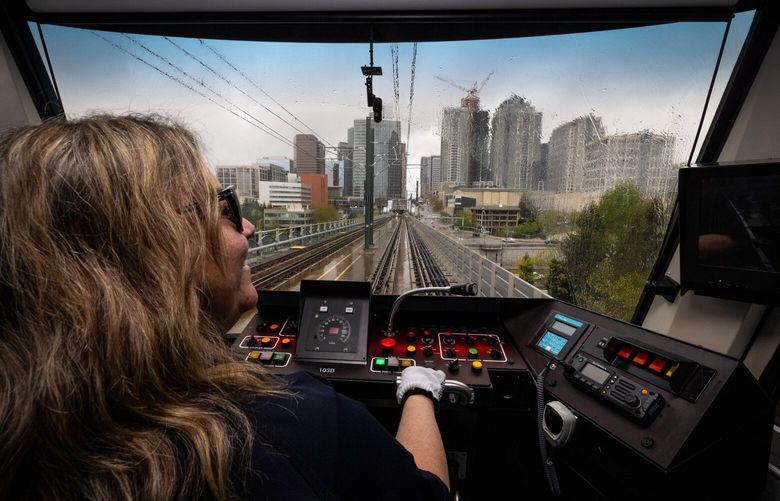 Heading south on the 2 Line, train operator Gina Sparrow takes news media aboard light rail into the Bellevue Downtown station as the city’s skyline looms in the background, Thursday, April 25, 2024 in Bellevue. The route opens to the public Saturday.