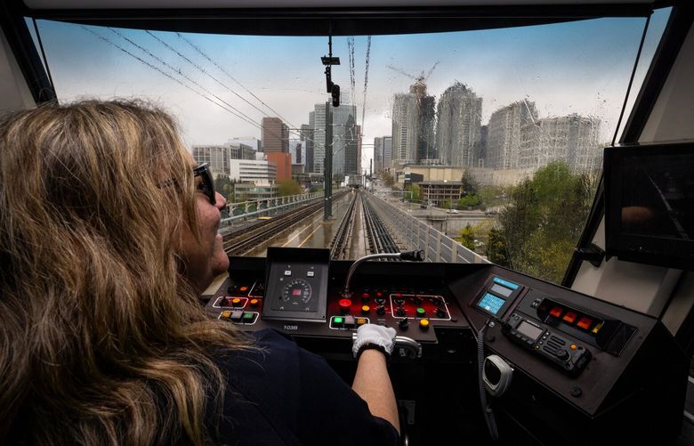 Heading south on the 2 Line, train operator Gina Sparrow takes news media aboard light rail into the Bellevue Downtown station as the city’s skyline looms in the background, Thursday, April 25, 2024 in Bellevue. The route opens to the public Saturday.