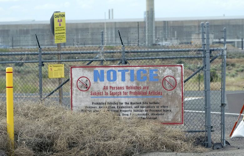Caution signs are shown at a gate on the Hanford Nuclear Reservation, Thursday, June 2, 2022, during a tour of the facility in Richland, Wash. by Washington Gov. Jay Inslee. Inslee, who has recently criticized the slow pace of cleaning up waste at the facility, repeated his message Thursday that more federal money is needed to finish the job. (AP Photo/Ted S. Warren)