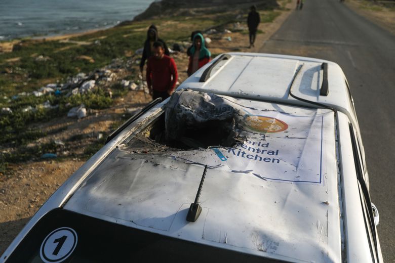 On Tuesday, April 2, 2024, Palestinians inspect a vehicle with the logo of the World Central Kitchen that was wrecked by an Israeli airstrike in Deir al Balah, Gaza Strip. A series of airstrikes killed seven aid workers from the international charity, leading it to suspend delivery of vital food aid to Gaza. (AP Photo/Ismael Abu Dayyah)