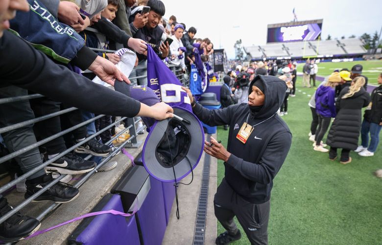 Michael Penix signs for fans during the Spring Game Friday.  The University of Washington Huskies played its Spring Game Friday, May 3, 2024 under the lights of Husky Stadium. (Dean Rutz / The Seattle Times)