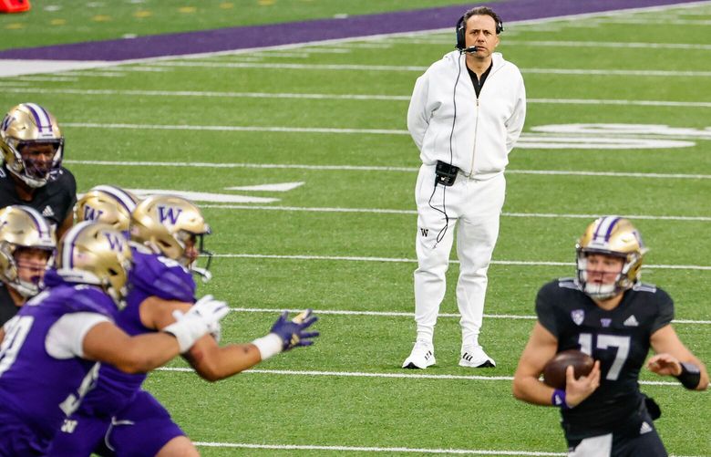 Washington first year coach Jedd Fisch stands in the backfield and watches the spring game play out Friday night.  Quarterback Teddy Purcell (17) finds a hole in the fourth quarter.  The University of Washington Huskies played its Spring Game Friday, May 3, 2024 under the lights of Husky Stadium. 226774