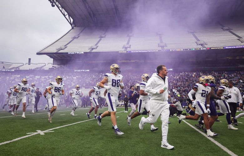 Jedd Fisch runs on to the turf of Husky Stadium for Saturday’s Spring Game.  The University of Washington Huskies played its Spring Game Friday, May 3, 2024 under the lights of Husky Stadium. 226774