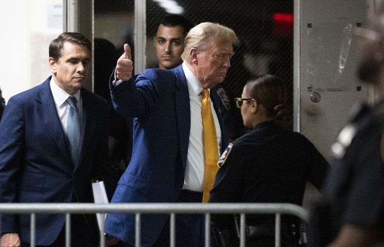 Flashing a thumbs-up, former President Donald Trump departs the courtroom for a break in his criminal trial in Manhattan on Thursday, May 2, 2024. Trump is accused of falsifying records to cover up a sex scandal that threatened to derail his 2016 presidential campaign and faces 34 felony counts. (Doug Mills/The New York Times)  XNYT0138 XNYT0138