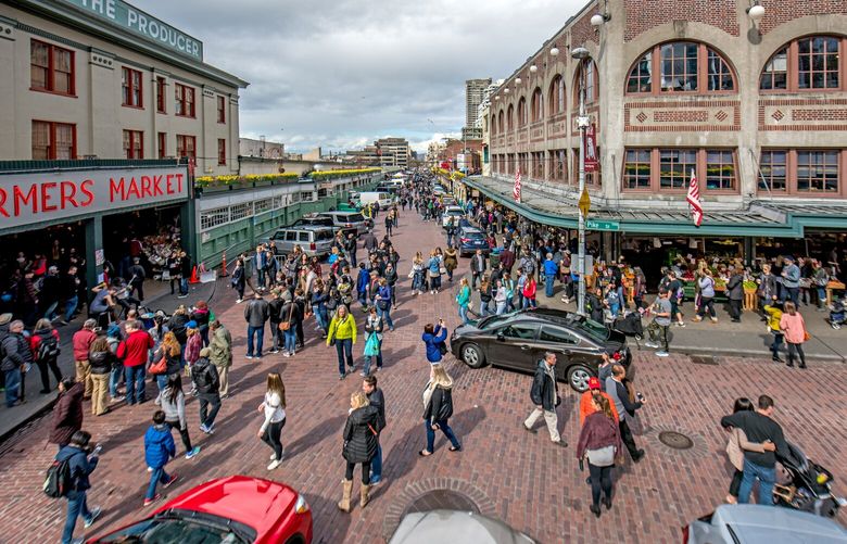 During this busy morning at the south end of the Market, pedestrians and vehicle traffic seem to co-exist in what has been called a “slow dance.”