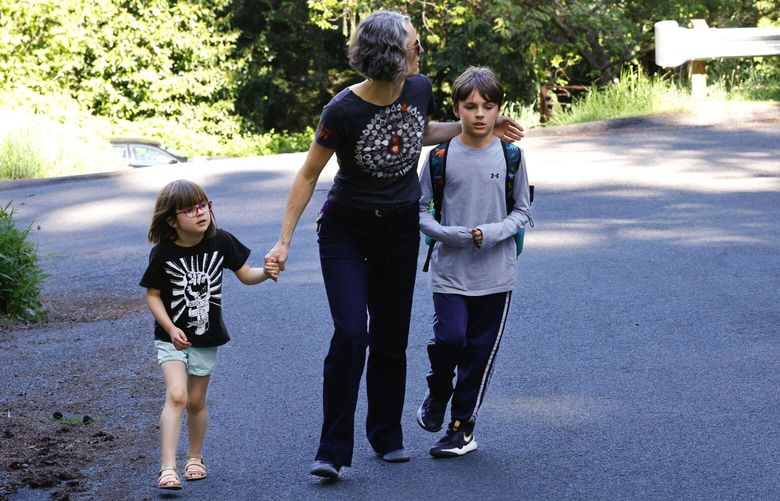 Megan Callow, parent of two, walks her kids home from Sacajawea Elementary School which her son Coleman, 9, attends in Seattle on May 9, 2024. June is her 5 year old daughter and hopes to go there next year.