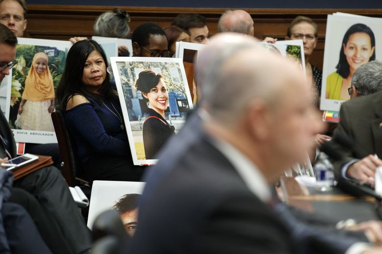 Family members of people who died in crashes of the Boeing 737 MAX hold photographs of their lost loved ones as FAA Administrator Stephen Dickson testifies during a House Transportation Committee hearing on the Boeing 737 MAX, on Dec. 11, 2019, in Washington, DC. (Jacquelyn Martin / AP)