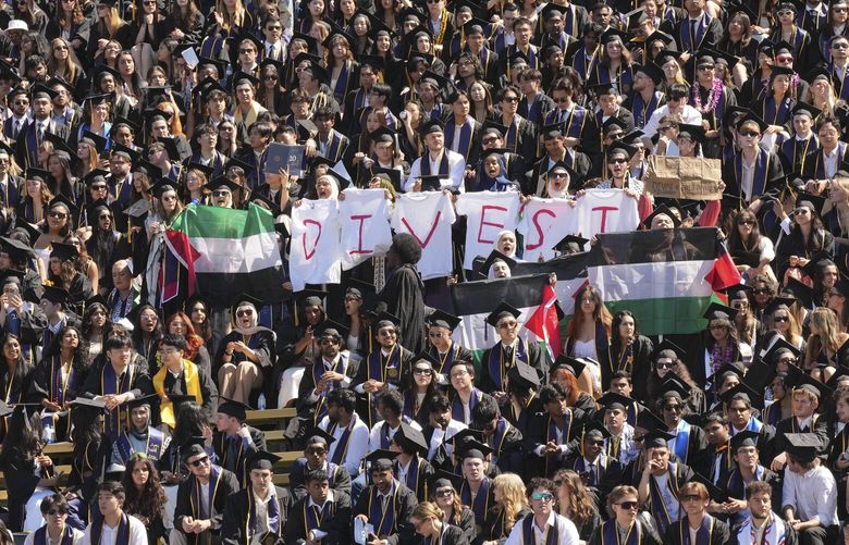 Students of the University of California, Berkeley, chant with a sign that reads “Divest” during a graduation ceremony at Memorial Stadium in Berkley, Calif., on Saturday, May 11, 2024. More than a dozen universities struck agreements with protesters that effectively conceded to some of their demands. Already, the agreements are under fire from all sides. (Jim Wilson/The New York Times)  XNYT0727 XNYT0727