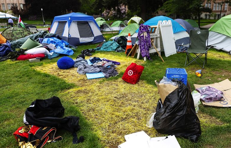 Discolored grass, clothes, blankets and other supplies remain where tents were erected inside an encampment, called Popular University for Gaza, in the Quad at the University of Washington on Friday, May 17, 2024, in Seattle.