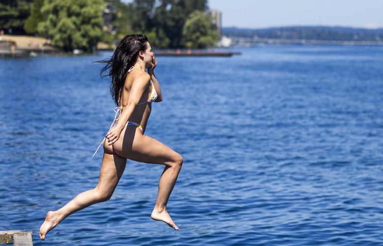 To escape the heat Alissa Pegram jumps into the cool Lake Washington on a hot day on Aug. 16, 2023.
