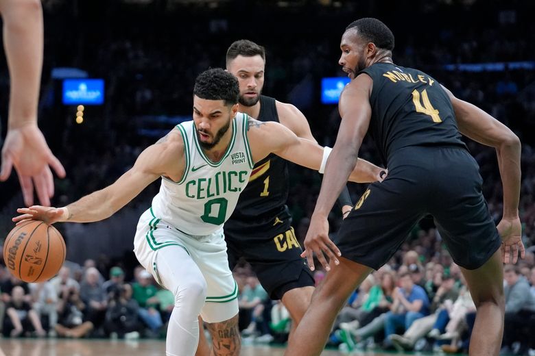 Boston Celtics forward Jayson Tatum, left, is defended by Cleveland Cavaliers guard Max Strus, behind, and forward Evan Mobley during the first half of Game 2 of an NBA basketball second-round playoff series Thursday, May 9, 2024, in Boston. (AP Photo/Steven Senne)