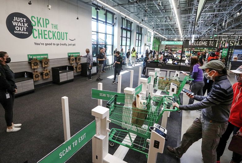 Customers use cashierless technology to check out at an Amazon Fresh grocery store in Bellevue in June 2021. (Ken Lambert / The Seattle Times, 2021)