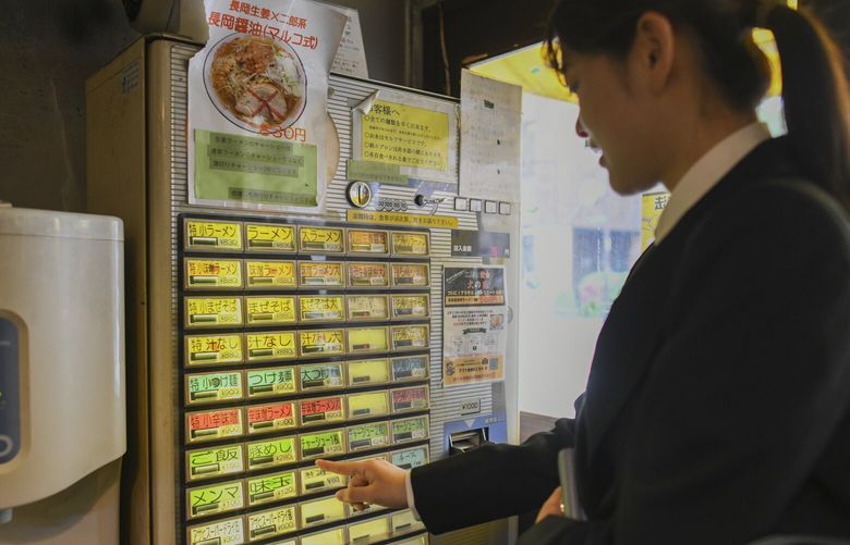 A customer buys a ticket for ramen at a vending machine at Goumen Maruko ramen shop in Tokyo, April 30, 2024. New yen notes set to be introduced this summer won’t be compatible with many machines that businesses like ramen shops rely on. (Noriko Hayashi/The New York Times) 