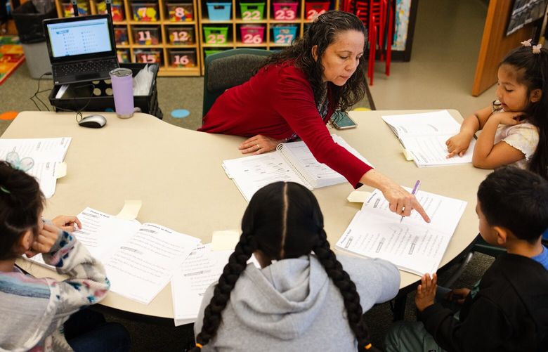 Marta McGrath helps a small group of kindergarten students during a class exercise at Wahitis Elementary School in Othello, Wash., on Tuesday, March 26, 2024.