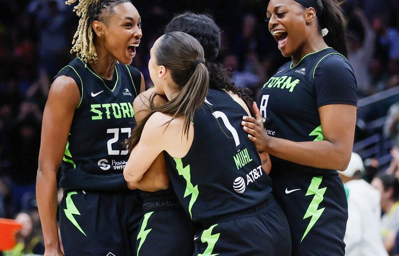 From left, teammates Seattle Storm guard Jordan Horston, guard Nika Muhl and forward Joyner Holmes surround guard Kiana Williams after Williams hit a long three as time expired during the fourth quarter Tuesday, June 11, 2024 in Seattle. 227115