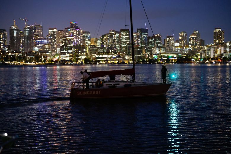 A boat heads home under the lights of the city after the Duck Dodge. After the weekly competition, boats raft up until 10 p.m. for a little community partying. (Karen Ducey / The Seattle Times)