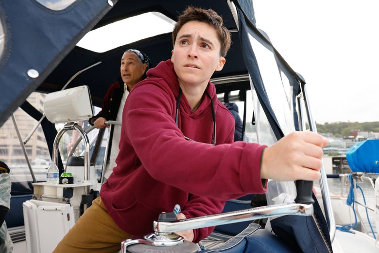 Taylor Zimmerman grinds the winch that adjusts the sail into position onboard the SV Mischief. (Karen Ducey / The Seattle Times)