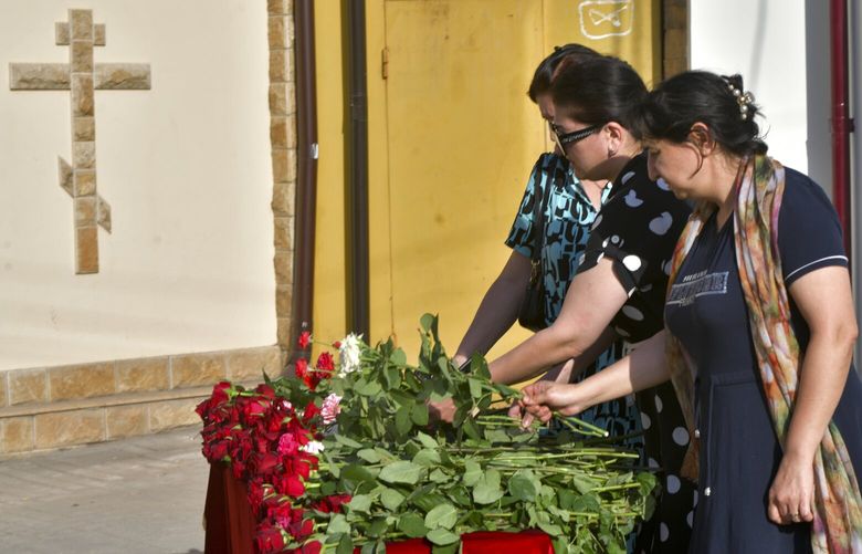 Women lay flowers at a makeshift memorial in front of the Holy Assumption Cathedral after an attack by Islamic militants in Makhachkala, republic of Dagestan, Russia, Monday, June 24, 2024. The attacks took place Sunday night in the city of Derbent and the regional capital of Makhachkala. A group of armed men attacked a synagogue and an Orthodox church in Derbent, the Interior Ministry said. (AP Photo) XAZ125 XAZ125