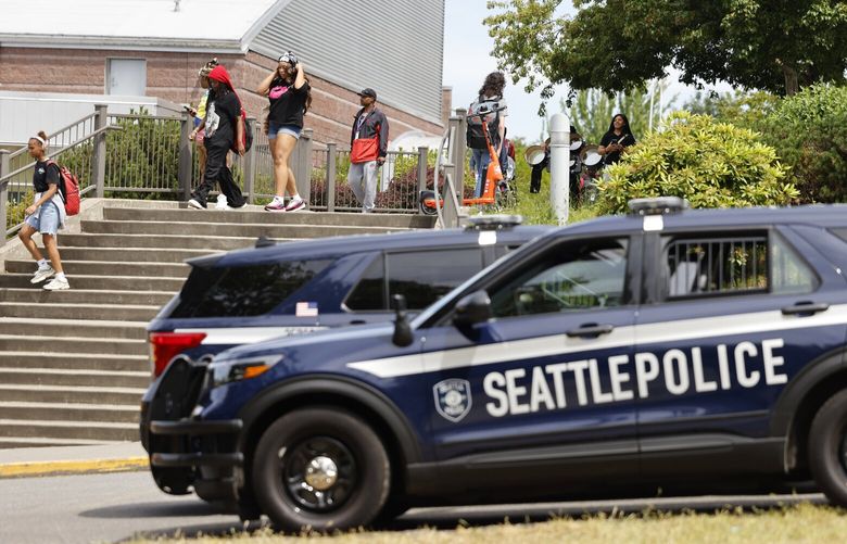 Police cars are seen outside as students leave Garfield High School on the last day of classes in Seattle on Friday, June 21, 2024. School security continues to patrol the perimeter of Garfield High School more than two weeks after the deadly shooting of student Amarr Murphy-Paine outside of the school.