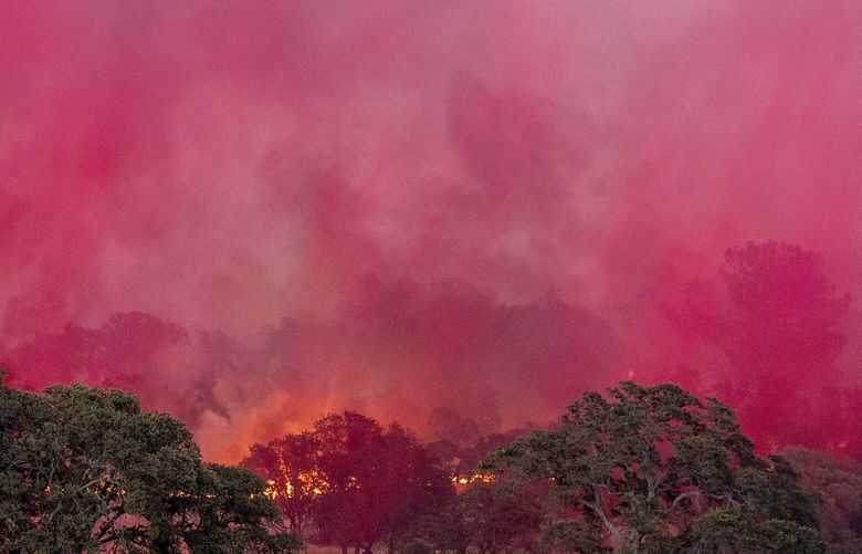 Fire retardant dropped from a plane drifts over the Aero Fire burning in the Copperopolis community of Calaveras County, Calif., on Monday, June 17, 2024. (AP Photo/Noah Berger) CANB101 CANB101