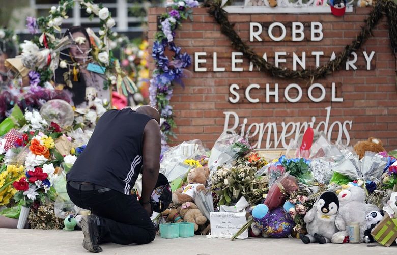 FILE – Reggie Daniels pays his respects a memorial at Robb Elementary School, June 9, 2022, in Uvalde, Texas, created to honor the victims killed in the school shooting. The former Uvalde schools police chief and another former officer have been indicted over their role in the slow police response to the 2022 massacre in a Texas elementary school that left 19 children and two teachers dead, according to multiple reports Thursday, June 27, 2024. (AP Photo/Eric Gay, File) NYAB401 NYAB401