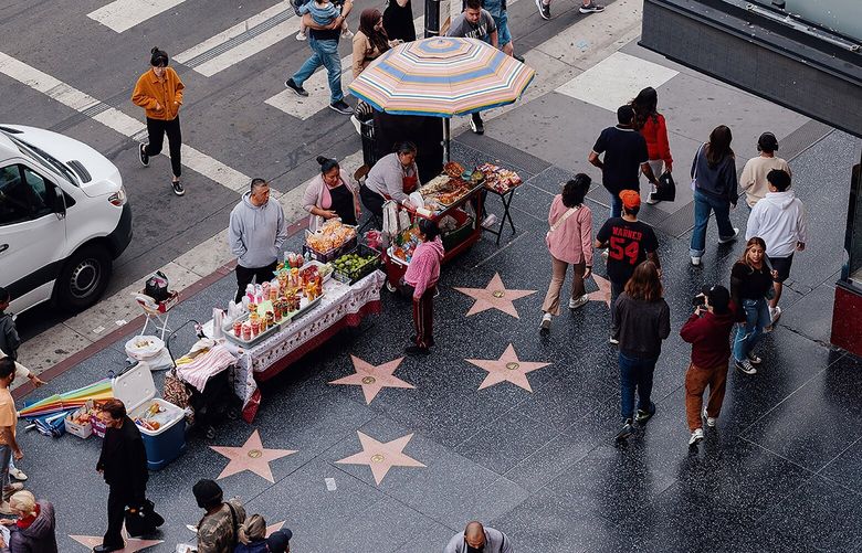  Street vendors sell their wares along the Hollywood Walk of Fame, which lines 15 blocks of Hollywood Boulevard, in Los Angeles, May 24, 2024. Los Angeles lifted restrictions that had forced the predominantly Latino and immigrant workforce of street vendors on Hollywood Boulevard to dodge citations, but other challenges remain. (Adam Perez/The New York Times) 