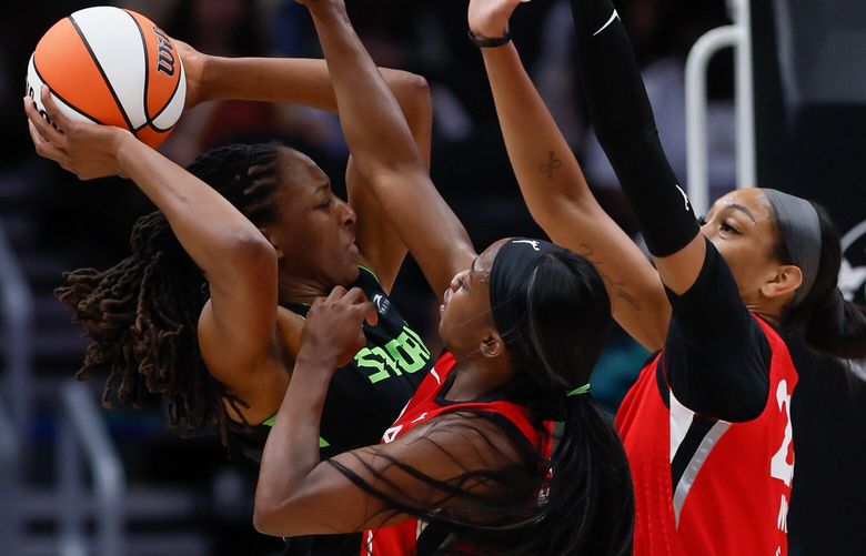 Seattle Storm forward Nneka Ogwumike gets hemmed in by Las Vegas Aces guard Jackie Young, center, and center A’ja Wilson during the first quarter Wednesday, July 10, 2024 in Seattle. 227420