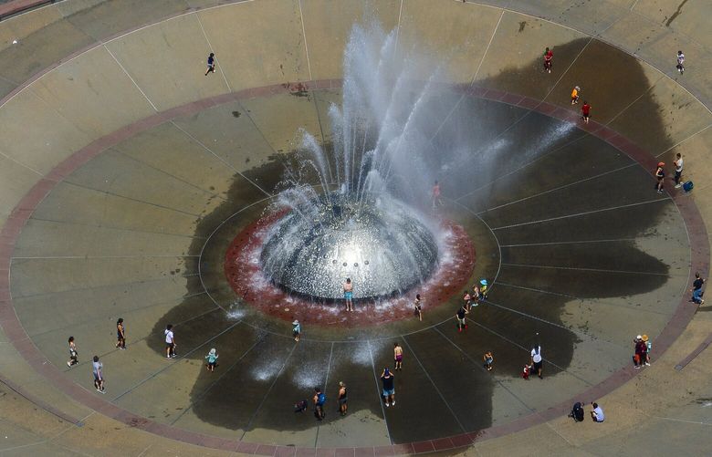 With temperature highs remaining in the 80s, sunworshipers gather around the International Fountain at Seattle Center for a wealth of weekend weather fun, Sunday, July 14, 2024.