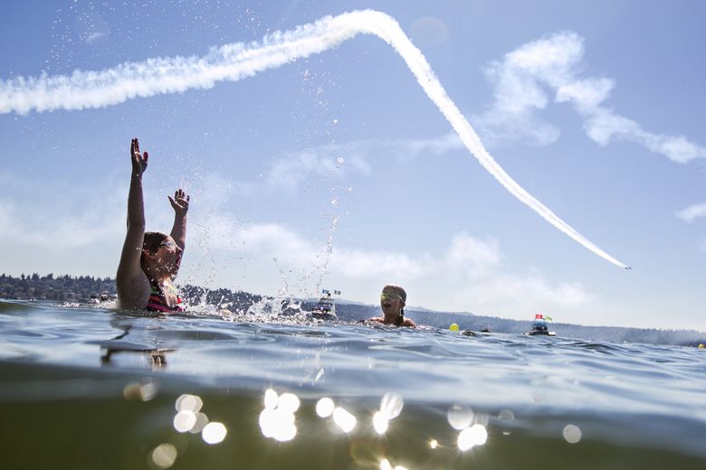 Both 12 at the time of this 2015 file photo, Natalie Hinkey and her twin sister Chloe, of Seattle, swim in Lake Washington as the Blue Angels practice. (Bettina Hansen / The Seattle Times, 2015)