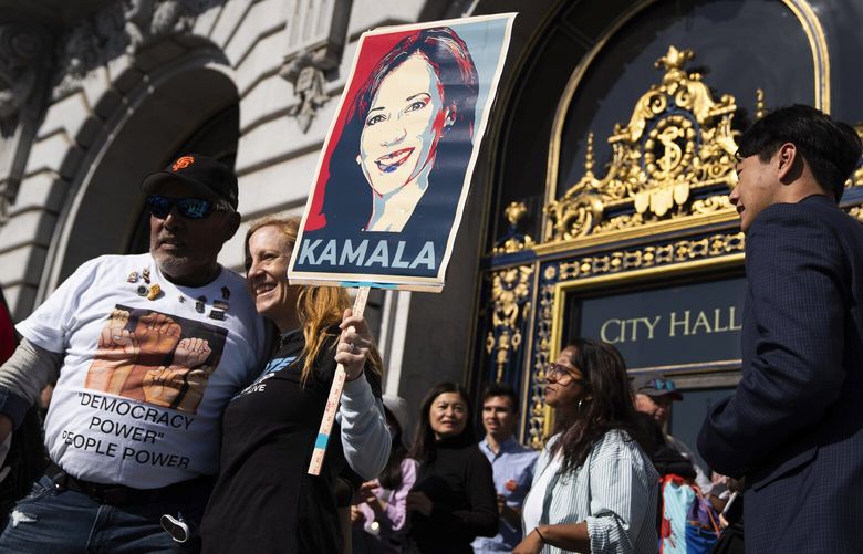 Jim Martinez, left, and Lanier Coles pose for a photo with a Kamala Harris sign after a rally in support of Harris at the San Francisco City Hall in San Francisco on Monday, July 22, 2024. (Minh Connors/San Francisco Chronicle via AP) CAFRA151 CAFRA151