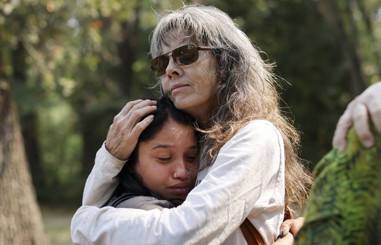 Nala Espinoza, left, and Linda Forrester hug during a community meeting at Cedar Grove Park in Chico, Calif., July 28, 2024. Many who fled the fire in California have been anxiously waiting to hear whether their houses are still standing. Others are grappling with news of homes and barns leveled by flames. (Daniel Dreifuss/The New York Times)