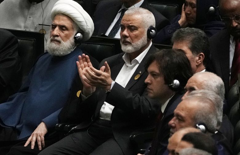 Hamas chief Ismail Haniyeh claps as newly-elected Iranian President Masoud Pezeshkian speaks while deputy leader of the Lebanese militant group Hezbollah, Sheikh Naim Kassem, left, sits during the swearing-in ceremony of Pezeshkian at the Iranian parliament, in Tehran, Iran, Tuesday, July 30, 2024. (Vahid Salemi / AP)