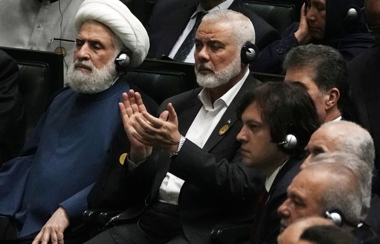 Hamas chief Ismail Haniyeh claps as newly-elected Iranian President Masoud Pezeshkian speaks while deputy leader of the Lebanese militant group Hezbollah, Sheikh Naim Kassem, left, sits during the swearing-in ceremony of Pezeshkian at the Iranian parliament, in Tehran, Iran, Tuesday, July 30, 2024. (AP Photo/Vahid Salemi)
