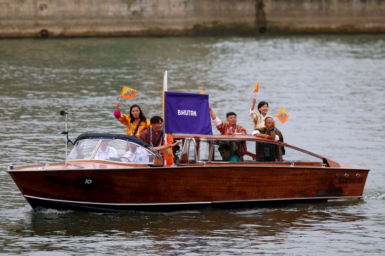 Team Bhutan go through the water curtain under the Austerlitz Bridge at the beginning of the athletes&#8217; parade on the Seine in Paris, France, during the opening ceremony for the 2024 Summer Olympics, Friday, July 26, 2024. (Michael Reaves/Pool Photo via AP)