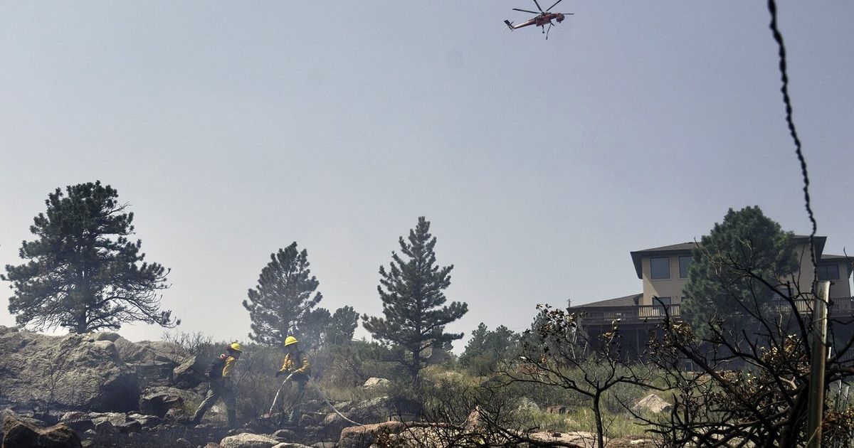 Wildfires encroach on homes near Denver as heat hinders fight