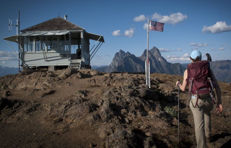 A hiker arrives at  the lookout on Desolation Peak, not far from Seattle, Sept. 16, 2012. The hike to Desolation Peak trail, where famous writer Jack Kerouac spent a summer as a fire lookout in 1956, can be as easy or as hard as you please with a boat ride up Ross Lake to the base of the mountain to camp, or a 3,500-foot climb to the peak with all the water you will need for the next day. (Ethan Todras-Whitehill/The New York Times) — PHOTO MOVED IN ADVANCE AND NOT FOR USE – ONLINE OR IN PRINT – BEFORE NOV. 18, 2012. —