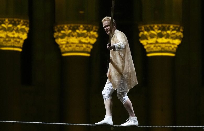Philippe Petit walks a tightrope inside the Cathedral Church of St. John the Divine to mark the 50th anniversary of his World Trade Center Twin Towers high-wire walk, on Wednesday, Aug. 7, 2024, in New York. (Photo by Charles Sykes/Invision/AP) NYCS103 NYCS103