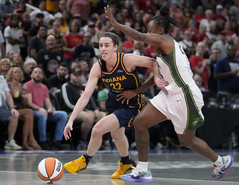 Indiana Fever&#8217;s Caitlin Clark (22) goes to the basket against Seattle Storm&#8217;s Jewell Loyd, right, during the first half of a WNBA basketball game, Sunday, Aug. 18, 2024, in Indianapolis. (AP Photo/Darron Cummings)