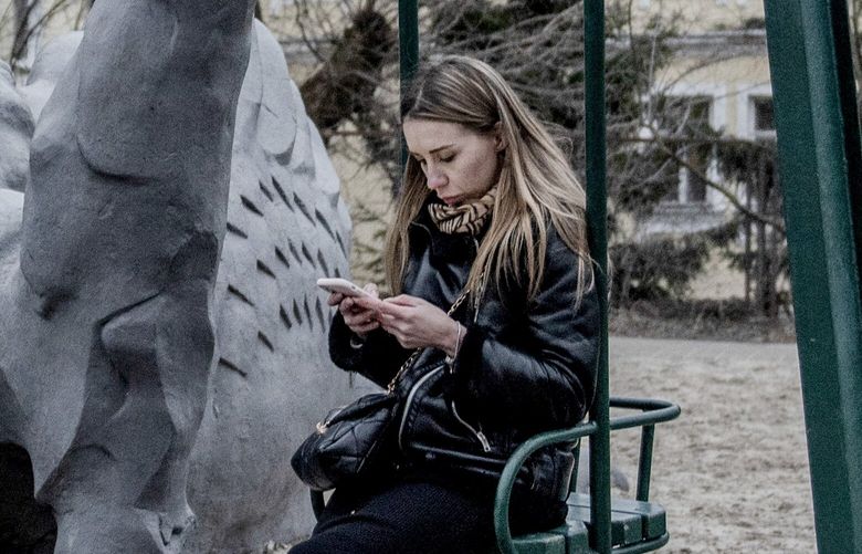 A mother reads news about the war on Telegram while her daughter plays in a park in Kyiv, on March 13, 2023. The detention of Pavel Durov, the founder of Telegram, has raised questions about the future of a platform that has come to define the public perception of Russia’s war in Ukraine. (Laetitia Vancon/The New York Times)