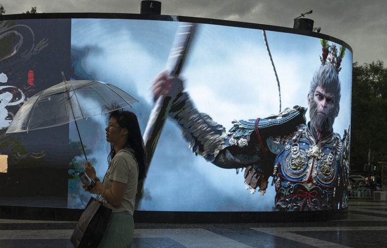 A woman walks past an ad promoting the latest blockbuster new Chinese video game “Black Myth: Wukong” in Beijing, Friday, Aug. 23, 2024. (AP Photo/Ng Han Guan) XHG108 XHG108