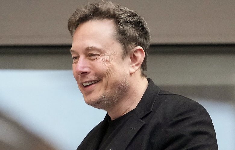 Elon Musk talks to other spectators while watching play between Jannik Sinner, of Italy, and Taylor Fritz, of the United States, during the men’s singles final of the U.S. Open tennis championships, Sunday, Sept. 8, 2024, in New York. (AP Photo/Kirsty Wigglesworth) USO148 USO148