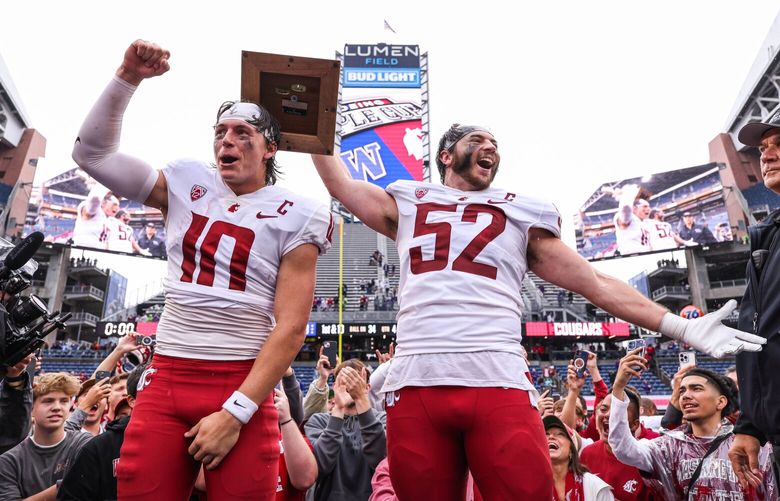 Washington State quarterback John Mateer, left, and linebacker Kyle Thornton celebrate with the Apple Cup Trophy after their 24-19 win over Washington Saturday. The Washington Huskies played the Washington State Cougars in the 116th edition of the Apple Cup game Saturday, Sept. 14, 2024 at Lumen Field, in Seattle, WA. 228030