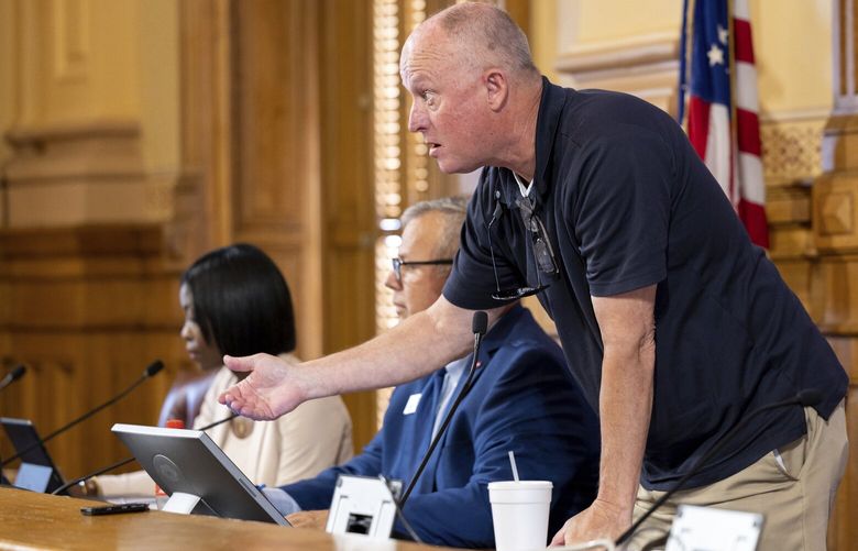 FILE – State Election Board member Rick Jeffares asks the crowd to settle down during a hastily planned State Election Board meeting at the Capitol in Atlanta on Friday, July 12, 2024. The Georgia State Election Board, which once toiled in relative obscurity, now hosts raucous meetings where public comment spans several hours and attendees regularly heckle its members. (Arvin Temkar/Atlanta Journal-Constitution via AP, File) GAATJ402 GAATJ402