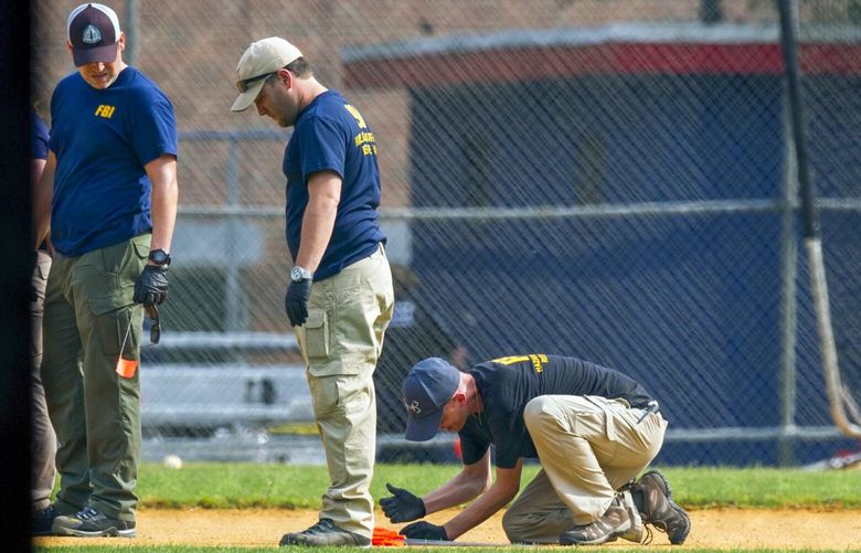 A FBI Evidence Response Team marks evidence on the ball field which is the scene of a multiple shooting in Alexandria, Va., Wednesday, June 14, 2017, after a rifle-wielding attacker opened fire on Republican lawmakers at a congressional baseball practice, wounding House GOP Whip Steve Scalise of Louisiana and several others as congressmen and aides dove for cover. VACO149