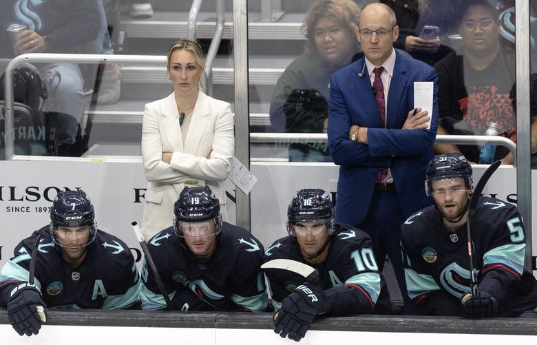 Head coach Dan Bylsma, right, and assistant coach Jessica Campbell coach the Kraken against the Flames in a preseason game last month. (Nick Wagner / The Seattle Times)