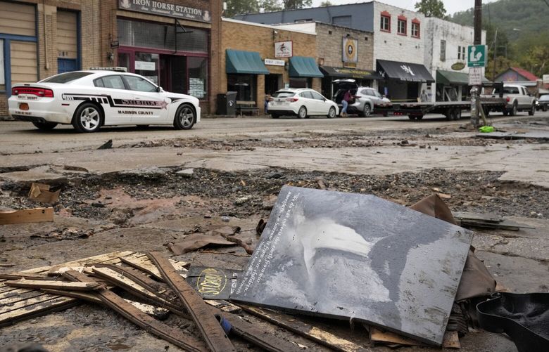A Madison County sheriff’s vehicle passes damaged buildings along Bridge Street in the aftermath of Hurricane Helene Tuesday, Oct. 1, 2024, in Hot Springs, N.C. (AP Photo/Jeff Roberson) NCJR103 NCJR103
