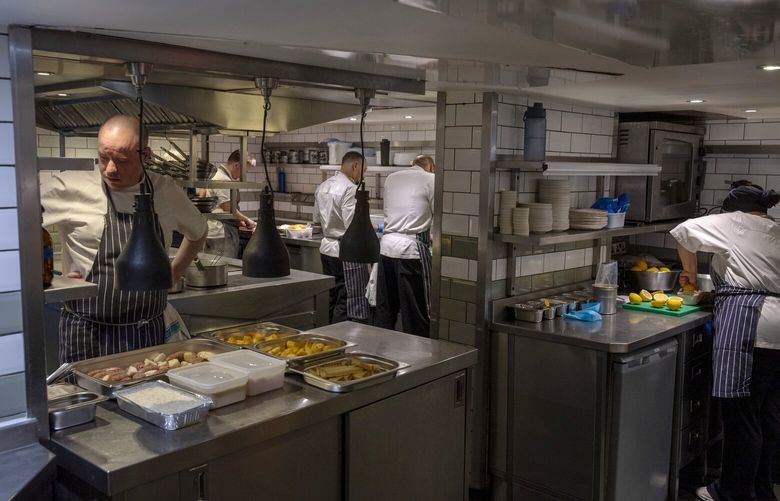 **EMBARGO: No electronic distribution, Web posting or street sales before Tuesday at 12:01 a.m. ET on Oct. 1, 2024. No exceptions for any reasons. EMBARGO set by source.** Staff at work in Home Kitchen, a new restaurant in London, Sept. 25, 2024. In the city’s upmarket Primrose Hill, a Michelin-starred chef is employing people on the edge of homelessness as chefs, wait staff and cocktail makers. (Andrew Testa/The New York Times) XNYT0779 XNYT0779