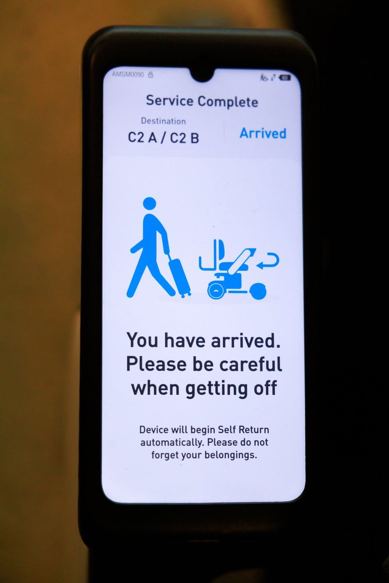 Автономное кресло-коляска Whill отображает сообщение при завершении обслуживания. (Эрика Шульц / Seattle Times)