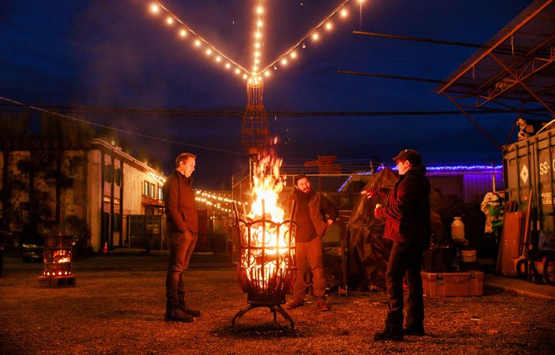 Firepit Fridays are a monthly ritual at Equinox Studios in Georgetown. Artists gather to eat, drink and talk around blazes in elaborate firepits made by metalworkers who have studios in the complex. Founder Sam Farrazaino is at left. (Erika Schultz / The Seattle Times)